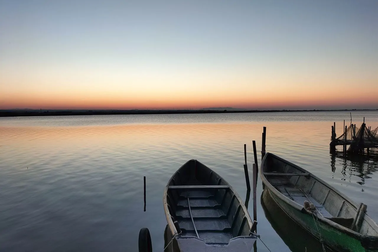 Boote im Morgengrauen auf dem Varano-See, an der Nordseite der Halbinsel